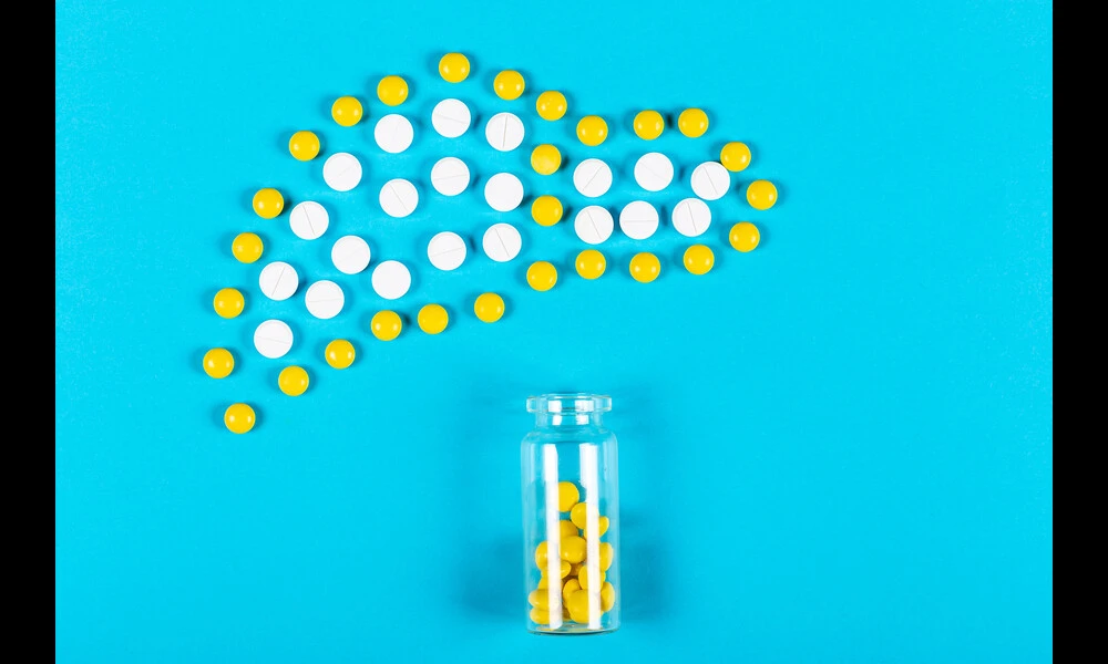 Bottle with scattered yellow pills and liver from pills on blue background | Marco Verch on Flickr