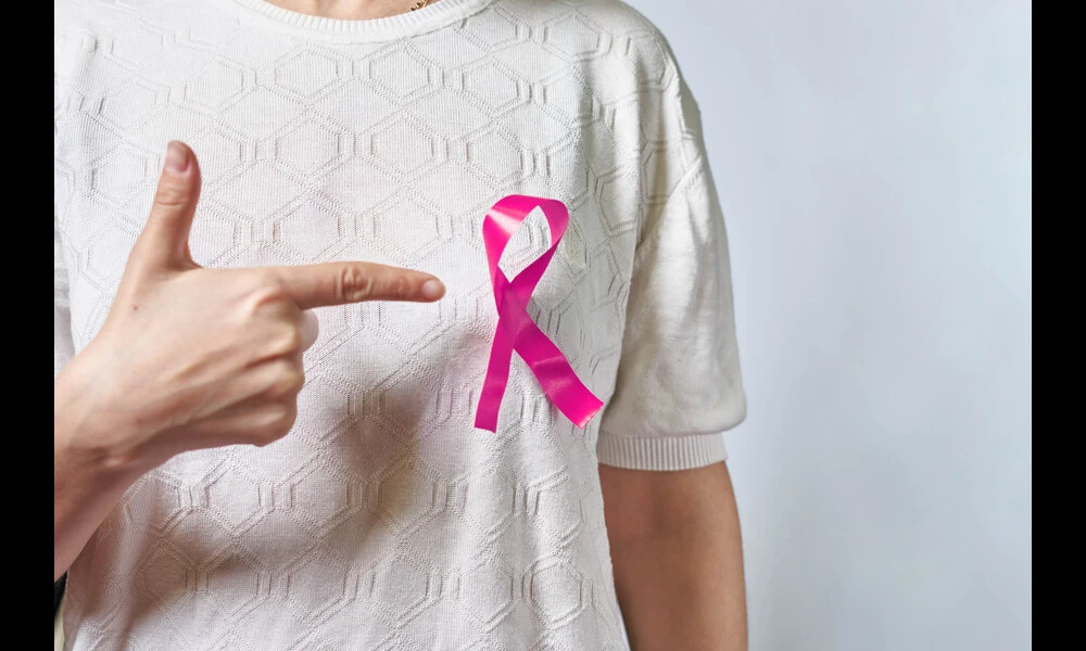A pink badge ribbon on woman chest to support breast cancer cause | Marco Verch on Flickr